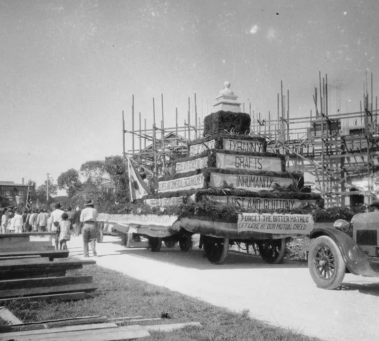 Baguio, Benguet, ~1928. 'Large pyramid shaped parade float with English slogans'.